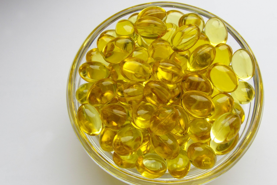 A bowel of vitamin D supplements on a white table