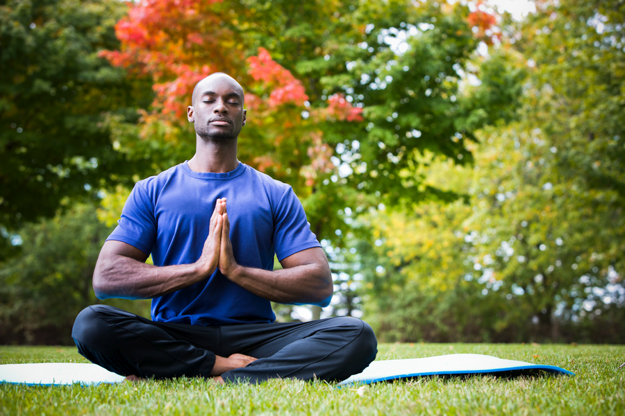 Muscular young man in a meditative pose practicing semen retention.